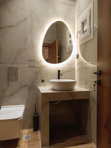 a bathroom with a sink and a mirror at Eden's Garden luxury Studio in Kalamitsi