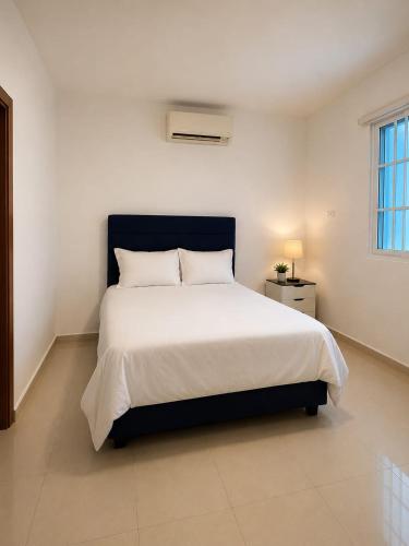 a bedroom with a large bed in a white room at CEDOTURT Hotel Boutique & Escuela in Santo Domingo