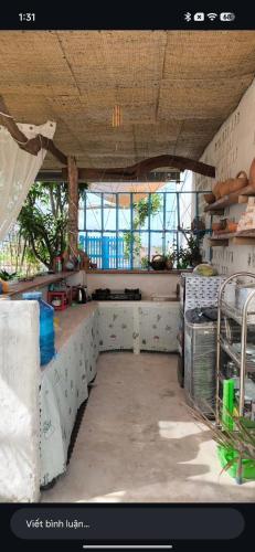 a kitchen with a counter in a room with windows at Homestay Nhà Có Gió in Thôn Mỹ Tường