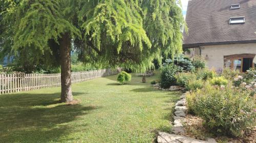 a tree in a yard next to a house at Villanath in Bellegarde-sur-Valserine