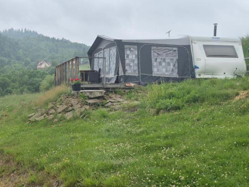 a trailer sitting on top of a grassy hill at Camping Obłazek in Piwniczna-Zdrój