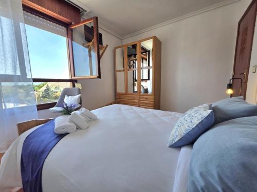 a bedroom with a large white bed with blue pillows at Apartamento Viento y Marea 20811 in Argoños