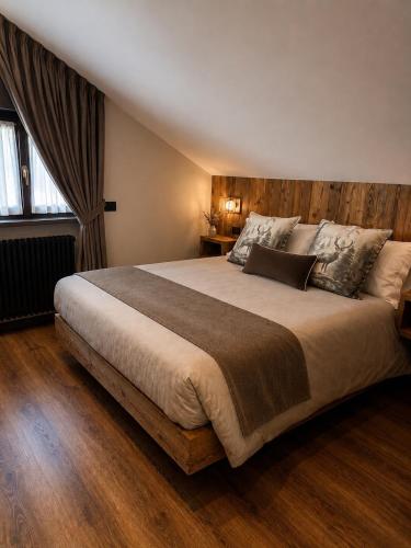 a bedroom with a large bed with a wooden headboard at Appartamento Arisch in Aprica
