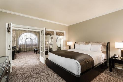 una camera d'albergo con un grande letto e una scrivania di Montecito Inn a Santa Barbara