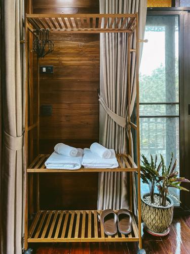 a wooden bunk bed with towels and a window at Rommai Villa Chiang Rai in Ban Pa Sang (1)