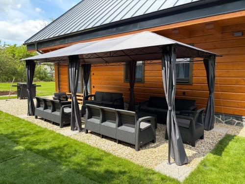 a gazebo with black furniture under it on a house at Chalupa Sandra in Vítějeves