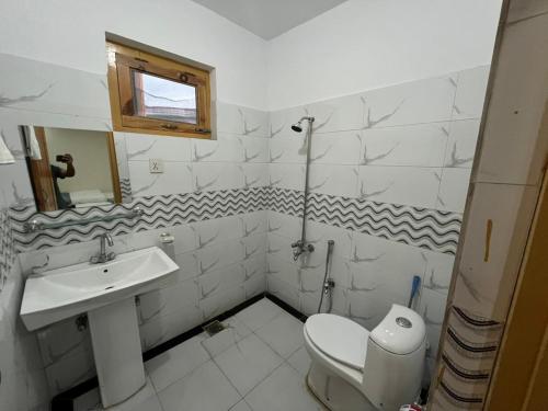 a white bathroom with a sink and a toilet at cloudrestskardu in Skardu