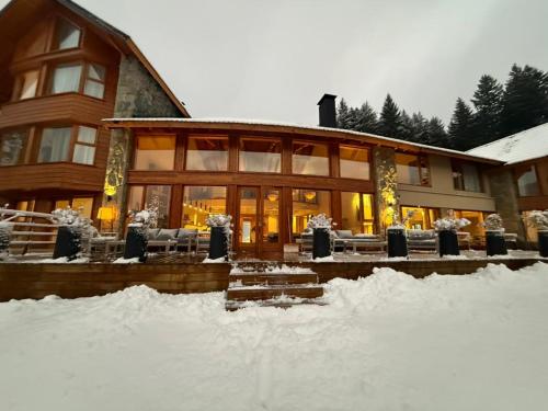 a large building with snow in front of it at Puerto Manzano Boutique Hotel in Villa La Angostura