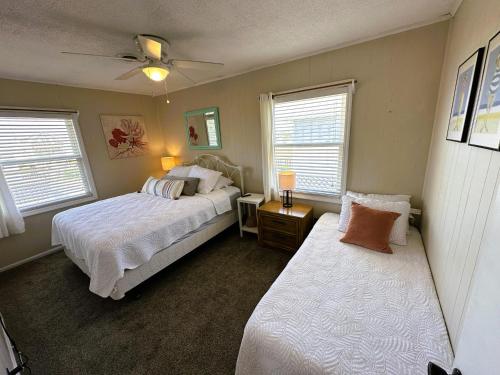 a bedroom with two beds and two windows at N6913- Heidaway (Formerly Devlin's Roost) in Nags Head