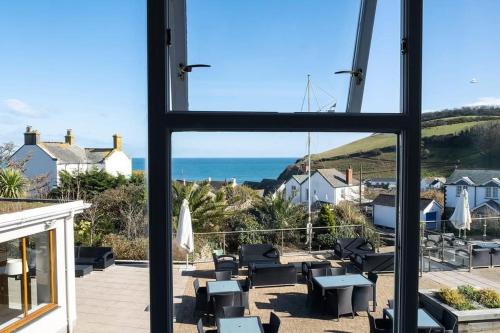 a view from a window of a patio with the ocean at The Llawnroc Hotel in Gorran Haven