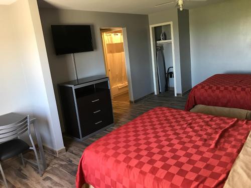 a hotel room with two beds and a flat screen tv at Express Inn Weslaco/Mercedes in Weslaco