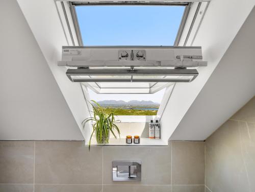 a skylight in a bathroom with a window at Sweet Garden in Ballyconneely