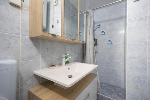 a bathroom with a white sink and a shower at Green Oasis by the Sea in Koper