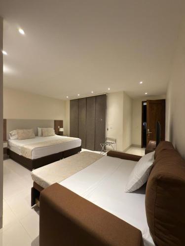 a bedroom with two beds and a couch at Hotel Campestre Santa Lucia in Montenegro