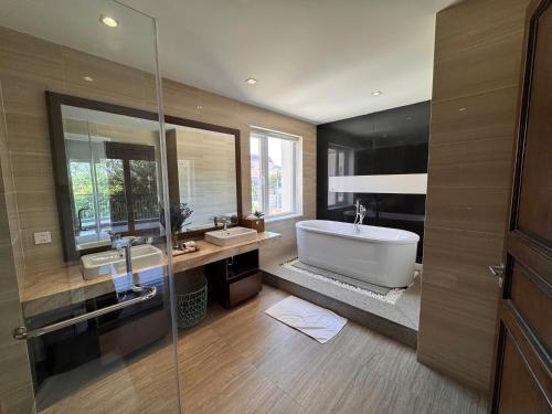 a bathroom with a tub and two sinks and a shower at An Nhien Mercury Villa & Resort in Phú Quốc