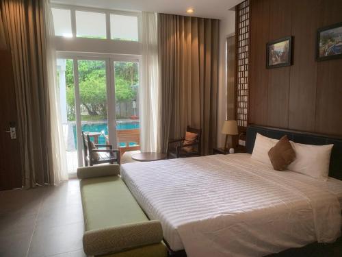 a bedroom with a large bed and a large window at An Nhien Mercury Villa & Resort in Phú Quốc