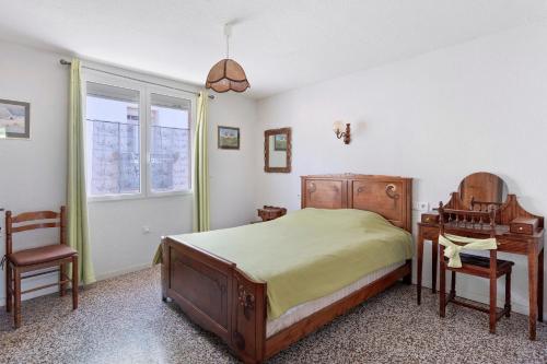a bedroom with a bed and a desk and a chair at Gîte rural chez Michel in Soulatgé
