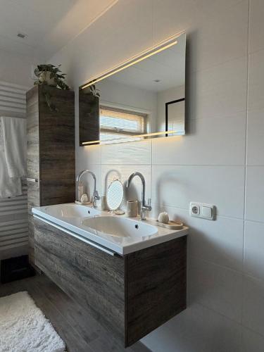 a bathroom with a large sink and a mirror at Maison Bo Luxury Stay in Historic Lemmer in Lemmer