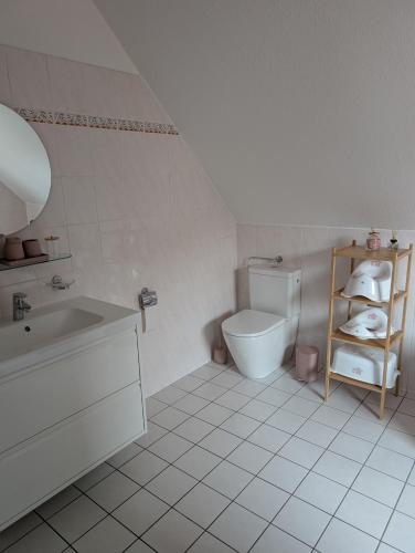 a white bathroom with a toilet and a sink at Apartment am Park Anklam in Anklam