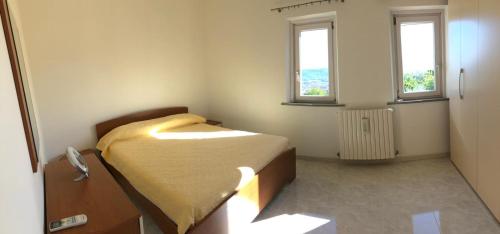 a small bedroom with a bed and two windows at Villa Maria Giuseppina a San Benedetto del Tronto in Monteprandone