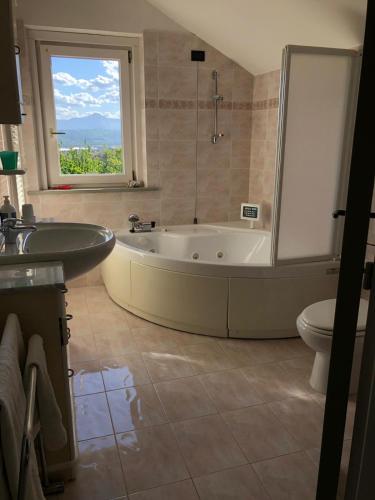 a bathroom with a tub and a sink and a window at Villa Maria Giuseppina a San Benedetto del Tronto in Monteprandone