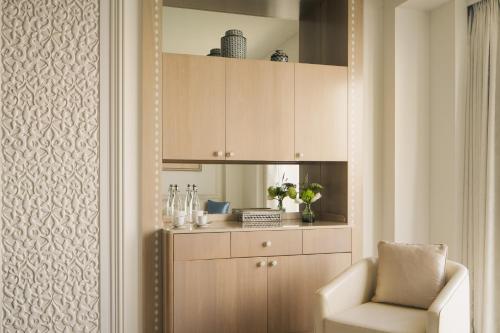 a living room with a chair and a cabinet at Four Seasons Hotel Doha in Doha