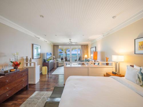 a bedroom with a bed and a living room at Villa 317 at Turtle Bay in Kahuku