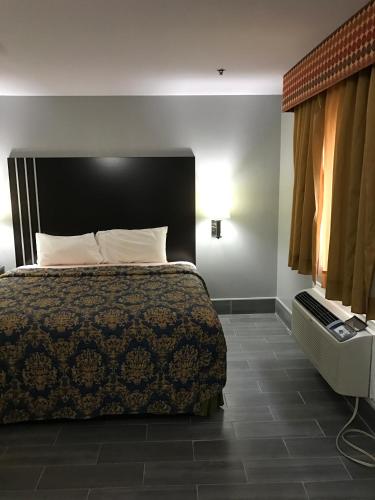 a bedroom with a bed with a black headboard at Express Inn Weslaco/Mercedes in Weslaco