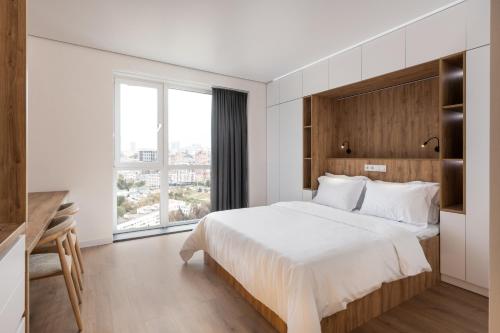 a bedroom with a large bed and a large window at Lumen Living in Kyiv