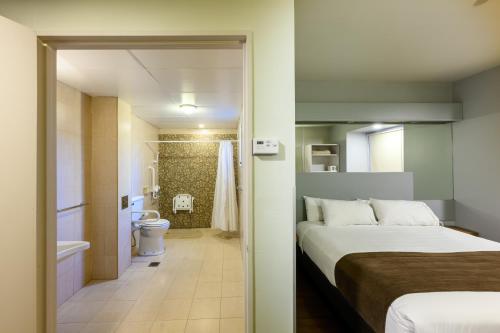 a hotel room with a bed and a bathroom at Hathor Hotels Mendoza in Mendoza