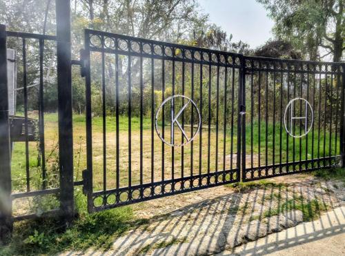 a black wrought iron fence with two anarchy signs on it at Kutumba Home in Bhairāhawā