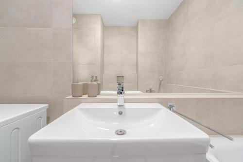 a white bathroom with a sink and a tub at Apartment TOMI - Olivia Residence in Trnávka