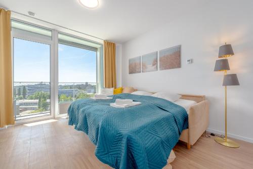 a bedroom with a bed with a blue blanket on it at Apartment TOMI - Olivia Residence in Trnávka