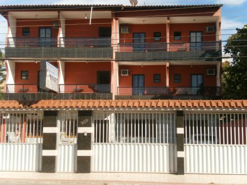 an orange building with white fences in front of it at Pousada da Zezé in Guarapari