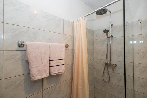 a shower with white towels and a shower curtain at Sea Breeze Retreat in Strožanac