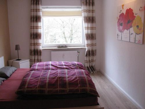 a bedroom with a bed and a window at Ferienwohnung Oelstorf in Eckernförde