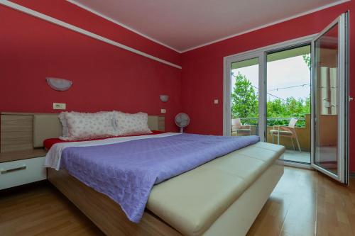 a red bedroom with a large bed and a balcony at Sea Breeze Retreat in Strožanac