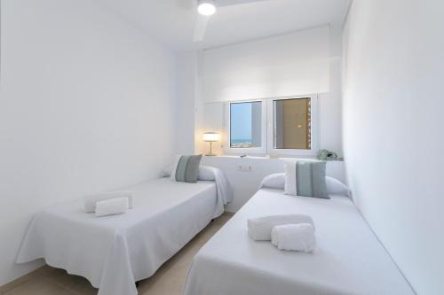a white room with two beds and two windows at AG LAS SIRENAS in Playa de Gandia