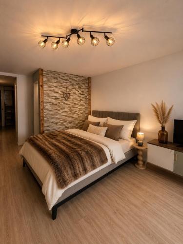 a bedroom with a large bed and a brick wall at Holiday Leukerbad Ruhe Natur Berge Free Parking 80 in Leukerbad
