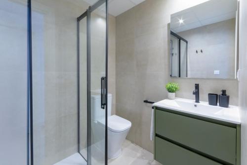 a bathroom with a toilet and a sink and a mirror at AG LAS SIRENAS in Playa de Gandia