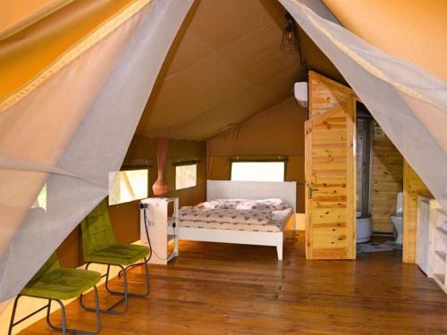 a tent with a bed and two chairs in a room at Царів Хутір in Tsarivka