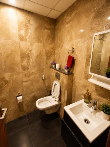 a bathroom with a toilet and a sink at Darshana Studios#Cozy in Noida