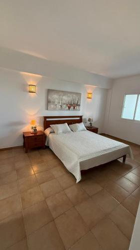 a bedroom with a large bed and two tables at Spacious Apartment with views to sea and pool Kabila vista Families only in Marina Smir