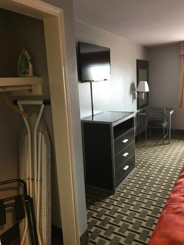a hotel room with a dresser with a lamp in it at Express Inn Weslaco/Mercedes in Weslaco
