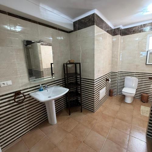 a bathroom with a sink and a toilet at Spacious Apartment with views to sea and pool Kabila vista Families only in Marina Smir