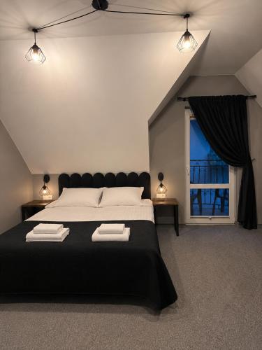a bedroom with a large bed and a window at Pensjonat Kocius in Rewal