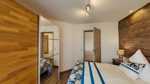 a bedroom with a bed and a wooden headboard at Exclusiv Apartment - Seepanorama in Schalkenmehren