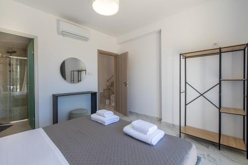 a bedroom with a bed with two towels on it at Casa Eda in Agia Marina Nea Kydonias