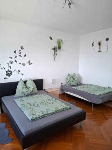 two beds in a living room with flowers on the wall at Ferienhaus Savannah in Schützen am Gebirge