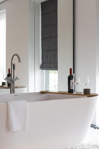 a kitchen with white cabinets and a sink with wine bottles at Lumen Living in Kyiv